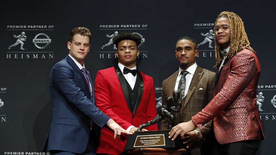 NCAA college football players and Heisman Trophy finalists, from left, LSU quarterback Joe Burrow, Ohio State quarterback Justin Fields, Oklahoma quarterback Jalen Hurts and Ohio State defensive end Chase Young pose for a photo with the Heisman Trophy, Saturday, Dec. 14, 2019, in New York. 