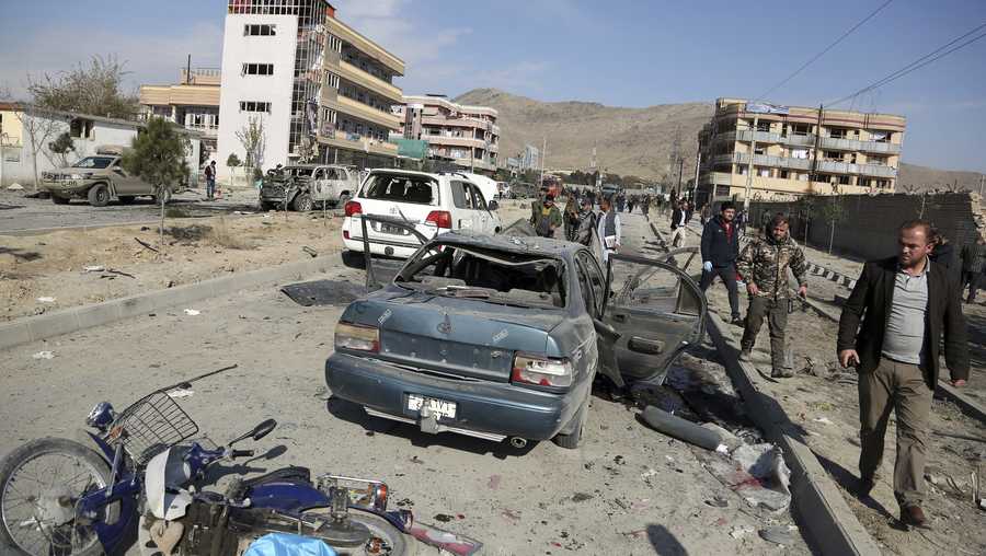 In this Nov. 13, 2019 file photo, Afghan security personnel gather at the site of a car bomb attack in Kabul, Afghanistan.