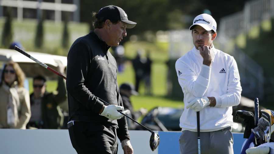 Phil Mickelson, left, and Nick Taylor, of Canada, talk while waiting to hit from the third tee of the Pebble Beach Golf Links during the final round of the AT&T Pebble Beach National Pro-Am golf tournament Sunday, Feb. 9, 2020, in Pebble Beach, Calif. (AP Photo/Eric Risberg)
