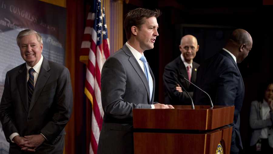 Sen. Ben Sasse, R-Neb., center, accompanied by Sen. Lindsey Graham, R-S.C., left, Sen. Tim Scott, R-S.C., right, and Sen. Rick Scott, R-Fla., second from right, speaks at a news conference about the coronavirus relief bill at a news conference on Capitol Hill in Washington, Wednesday, March 25, 2020. The Senators discussed what they are calling a "drafting error" in the $2 trillion stimulus bill. (AP Photo/Andrew Harnik)