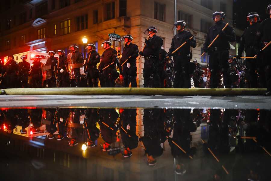 Police are reflected as they stand guard Saturday in Philadelphia, during a protest over the death of George Floyd.