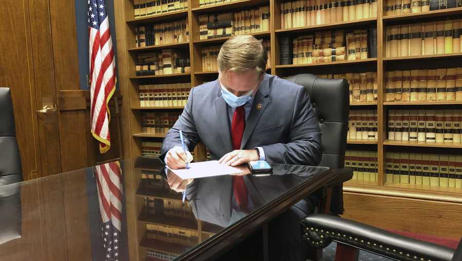 In this Tuesday, May 26, 2020 photo, U.S. Rep. Steve Watkins, R-Kan., fills out the necessary paperwork at the Kansas secretary of state&apos;s office in Topeka, Kan., to get his name on the ballot for re-election. Watkins is facing a tough primary challenge from State Treasurer Jake LaTurner. (AP Photo/John Hanna)
