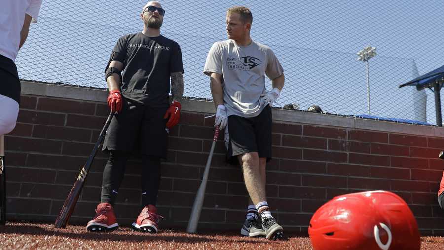 Cincinnati Reds&apos; Tucker Barnhart, left, talks with Josh VanMeter during a workout at Grand Park, Friday, June 12, 2020, in Westfield, Ind. Proceeds from the event will go to Reviving Baseball in the Inner City of Indianapolis. (AP Photo/Darron Cummings)