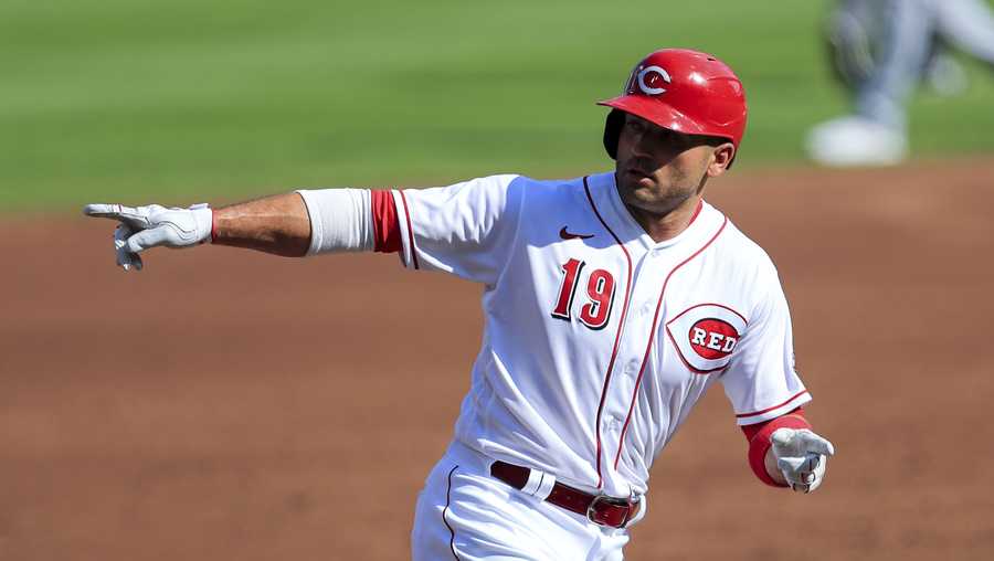 Cincinnati Reds&apos; Joey Votto (19) points to members of the grounds crew after he hit a solo home run in the first inning during a baseball game against the Detroit Tigers at Great American Ballpark in Cincinnati, Saturday, July 25, 2020. (AP Photo/Aaron Doster)