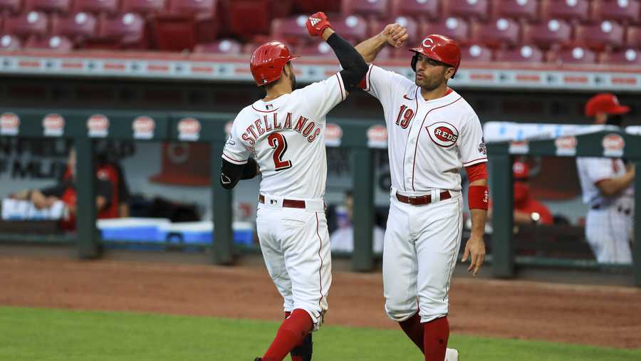 Cincinnati Reds&apos; Nicholas Castellanos celebrates with Joey Votto (19) after hitting a grand slam in the fifth inning of the team&apos;s baseball game against the Chicago Cubs in Cincinnati, Wednesday, July 29, 2020. (AP Photo/Aaron Doster)