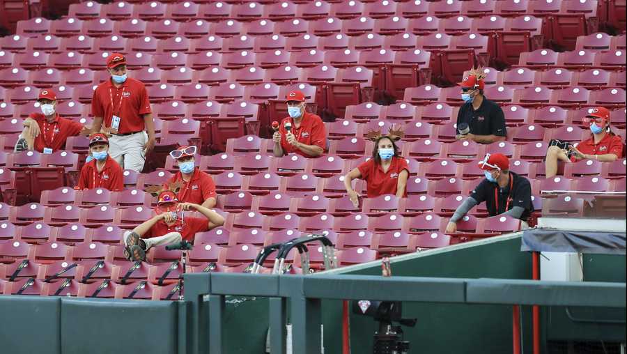 Members of the grounds crew react and make noise from the stands in the fourth inning during a baseball game between the Chicago Cubs and the Cincinnati Reds in Cincinnati, Wednesday, July 29, 2020. (AP Photo/Aaron Doster)