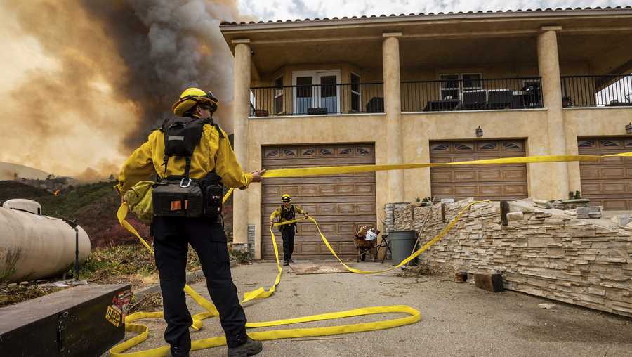 Firefighters prepare to defend a home as flames from the River Fire approaches in Salinas, Calif., on Monday, Aug. 17, 2020. Fire crews across the region scrambled to contain dozens of blazes sparked by lightning strikes as a statewide heatwave continues. (AP Photo/Noah Berger)