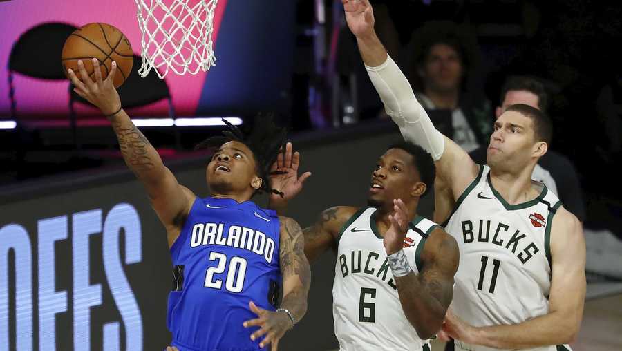 Orlando Magic guard Markelle Fultz (20) shoots in front of Milwaukee Bucks guard Eric Bledsoe (6) and center Brook Lopez (11) during the first half of Game 1 of an NBA basketball first-round playoff series, Tuesday, Aug. 18, 2020, in Lake Buena Vista, Fla. (Kim Klement/Pool Photo via AP)