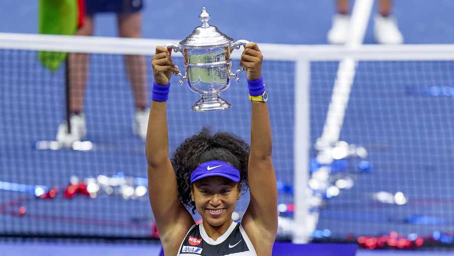 Naomi Osaka, of Japan, holds up the championship trophy after defeating Victoria Azarenka, of Belarus, in the women&apos;s singles final of the US Open tennis championships, Saturday, Sept. 12, 2020, in New York. (AP Photo/Frank Franklin II)