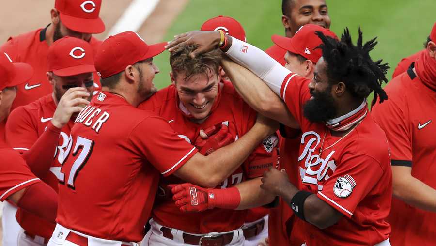 Cincinnati Reds&apos; Trevor Bauer, left, hugs Tyler Stephenson, center, after Stephenson hit a walkoff two-run home run in the seventh inning while Brian Goodwin, right, reacts during a baseball game against the Pittsburgh Pirates in Cincinnati, Monday, Sept. 14, 2020. (AP Photo/Aaron Doster)