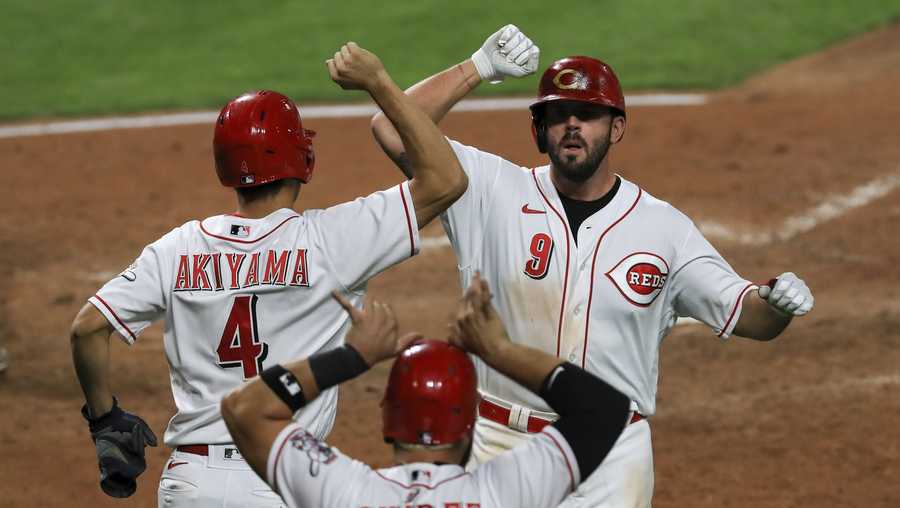 Cincinnati Reds&apos; Shogo Akiyama, left, celebrates a three-run home run by Mike Moustakas, right, in the fifth inning during a baseball game against the Pittsburgh Pirates in Cincinnati, Monday, Sept. 14, 2020. (AP Photo/Aaron Doster)