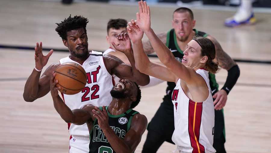 Boston Celtics guard Kemba Walker (8) attempts to maintain control of the ball in front of Miami Heat forward Jimmy Butler (22) and Kelly Olynyk, right, during the second half of an NBA conference final playoff basketball game, Thursday, Sept. 17, 2020, in Lake Buena Vista, Fla. (AP Photo/Mark J. Terrill)