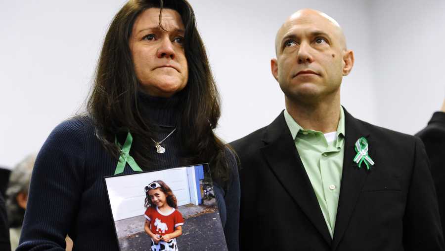 Jennifer Hensel, holding a portrait of her daughter, Sandy Hook School shooting victim Avielle Rose Richman, stands with her husband Jeremy Richman at a news conference at Edmond Town Hall in Newtown, Conn., Monday, Jan. 14, 2013. One month after the mass school shooting at Sandy Hook Elementary School, the parents joined a grassroots initiative called Sandy Hook Promise to support solutions for a safer community