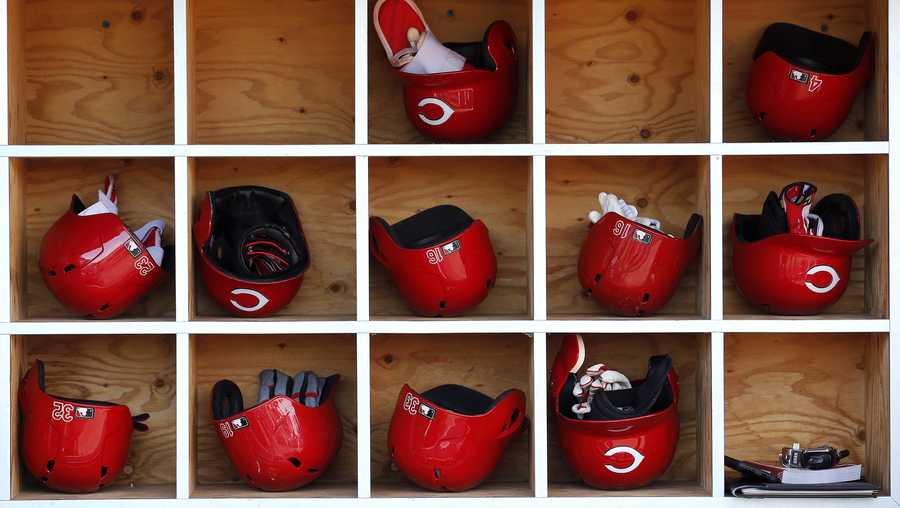 Inside the Cincinnati Reds dugout batting helmets wait to be used prior to a spring training baseball game against the Los Angeles Angels Monday, March 14, 2016, in Tempe, Ariz. (AP Photo/Ross D. Franklin)