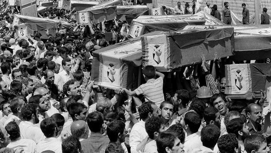 Mourners carry coffins through the streets of Tehran during a mass funeral for the victims aboard Iran Air Flight 655, which was shot down by the USS Vincennes in the Persian Gulf, July 7, 1988.