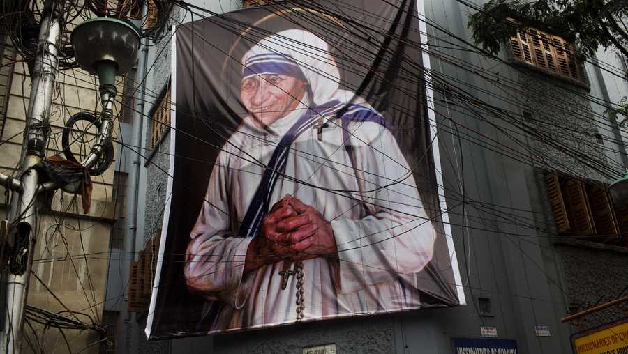 A giant picture of Mother Teresa is displayed outside the Missionaries of Charity Mother house in Kolkata, India, Saturday, Sept. 3, 2016. For many of the poor and destitute whom Mother Teresa served, the tiny nun was a living saint. Many at the Vatican would agree, but the Catholic Church nevertheless has a grueling process to make it official, involving volumes of historical research, the hunt for miracles and teams of experts to weigh the evidence. In Mother Teresa's case, the process will come to a formal end Sunday when Pope Francis declares the church's newest saint.
