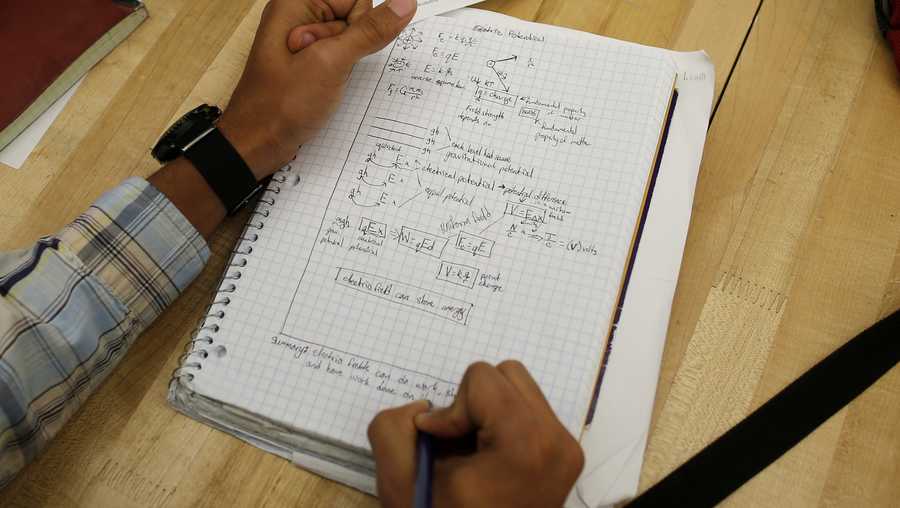 A student writes notes in the Advanced Placement (AP) Physics class at Woodrow Wilson High School in Washington, Friday, Feb. 7, 2014. (AP Photo/Charles Dharapak)