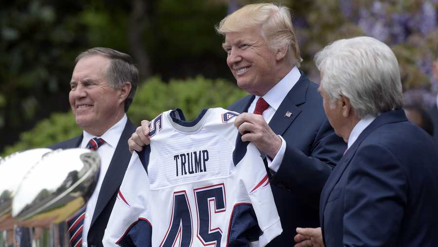 President Donald Trump holds up a New England Patriots jersey presented to him by Patriots owner Robert Kraft, right, and head coach Bill Belichick during a ceremony on the South Lawn of the White House in Washington, Wednesday, April 19, 2017, where the president honored the Super Bowl Champion New England Patriots for their Super Bowl LI victory. (AP Photo/Susan Walsh)