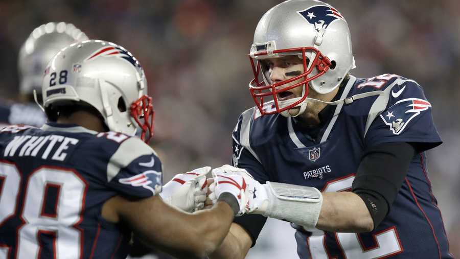 New England Patriots quarterback Tom Brady (12) celebrates a touchdown by running back James White (28) during the second half of the AFC championship NFL football game against the Jacksonville Jaguars, Sunday, Jan. 21, 2018, in Foxborough, Mass. (AP Photo/Charles Krupa)