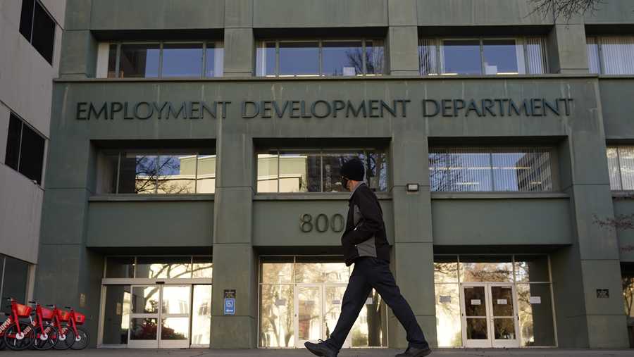 FILE - In this Dec. 18, 2020, file photo, a person passes the office of the California Employment Development Department in Sacramento, Calif. On Tuesday, Jan. 26, 2021, California State Auditor Elaine Howle released a report saying that the EDD might have overpaid millions of people since March 2020 after it stopped enforcing eligibility rules so they could process claims faster.