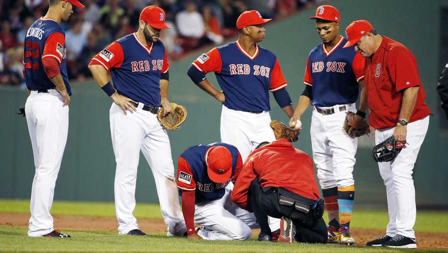 Boston Red Sox manager John Farrell, right, and players gather around Boston Red Sox's Eduardo Nunez, bottom left, after he was injured on a play during the second inning of a baseball game in Boston, Friday, Aug. 25, 2017.