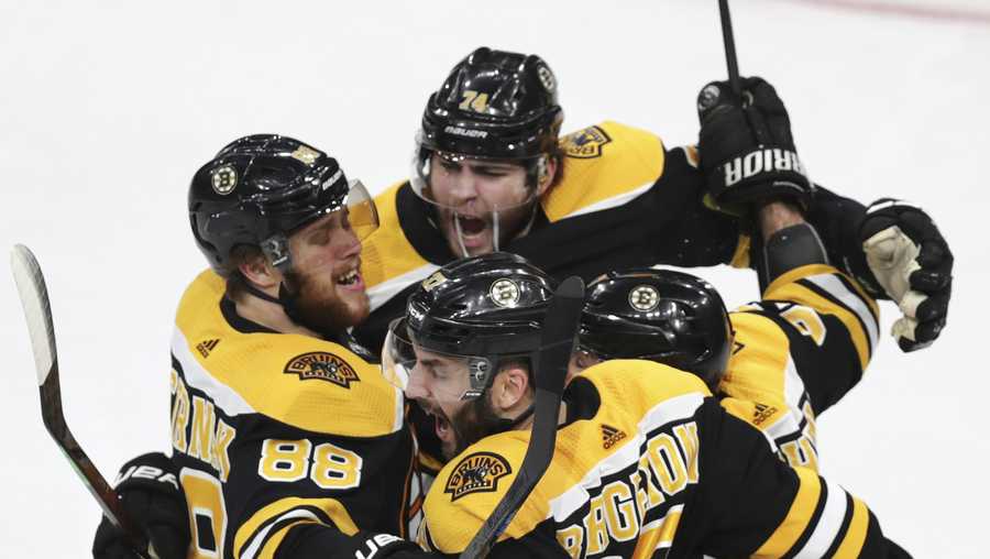 Boston Bruins' Patrice Bergeron (37) is congratulated by teammates after his goal against the Carolina Hurricanes during the third period in Game 1 of the NHL hockey Stanley Cup Eastern Conference finals, Thursday, May 9, 2019, in Boston. (AP Photo/Charles Krupa)