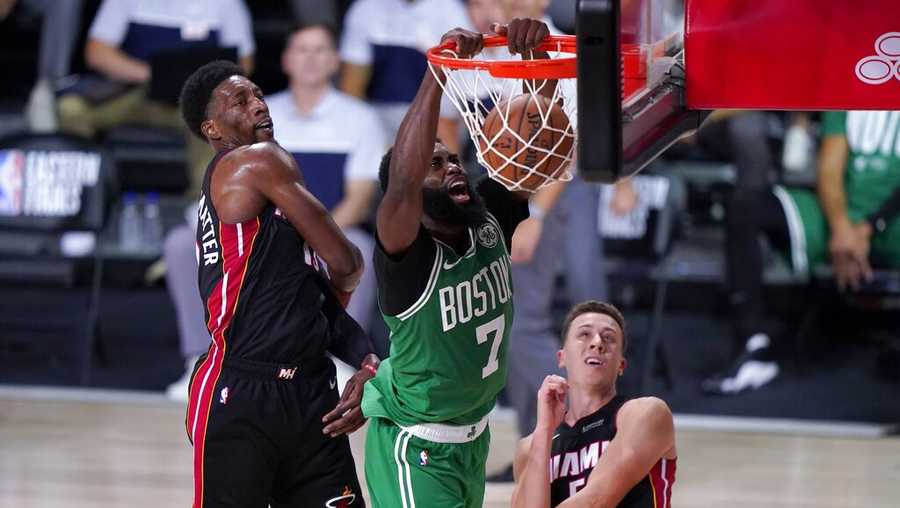 Boston Celtics guard Jaylen Brown (7) dunks the ball between Miami Heat&apos;s Bam Adebayo, left, and Duncan Robinson, right, during the second half of an NBA conference final playoff basketball game, Saturday, Sept. 19, 2020, in Lake Buena Vista, Fla. (AP Photo/Mark J. Terrill)