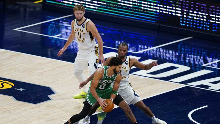 Boston Celtics&apos; Jayson Tatum (0) goes to the basket against Indiana Pacers&apos; T.J. Warren, right, during the second half of an NBA basketball game Tuesday, Dec. 29, 2020, in Indianapolis. (AP Photo/Darron Cummings)
