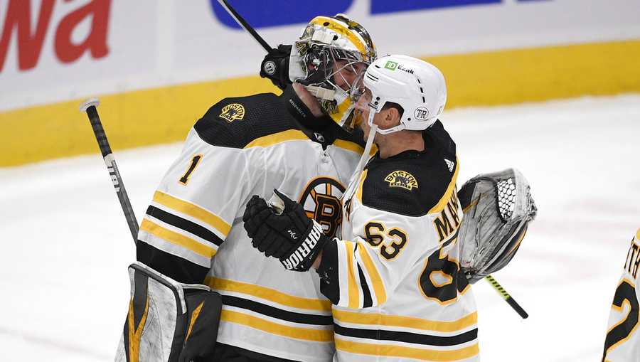 Boston Bruins goaltender Jeremy Swayman (1) and left wing Brad Marchand (63) celebrate after the team&apos;s NHL hockey game against the Washington Capitals, Thursday, April 8, 2021, in Washington. The Bruins won 4-2. (AP Photo/Nick Wass)