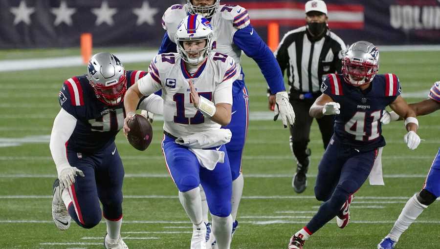 Buffalo Bills quarterback Josh Allen, center, runs from New England Patriots defenders Deatrich Wise Jr., left, and Myles Bryant, right, in the first half of an NFL football game, Monday, Dec. 28, 2020, in Foxborough, Mass. (AP Photo/Charles Krupa)