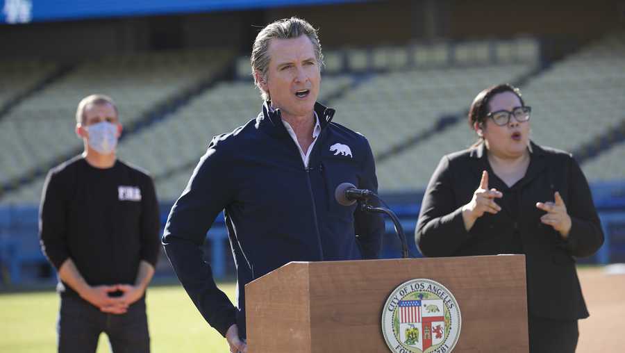 Governor Gavin Newsom addresses a press conference held at the launch of a mass COVID-19 vaccination site at Dodger Stadium, Friday, Jan. 15, 2021, in Los Angeles. Newsom and Los Angeles Mayor Eric Garcetti, left, touted the stadium as a new mass vaccination site while acknowledging they need clarity from the federal government on the availability of future vaccine supply. (Irfan Khan/Los Angeles Times via AP, Pool)