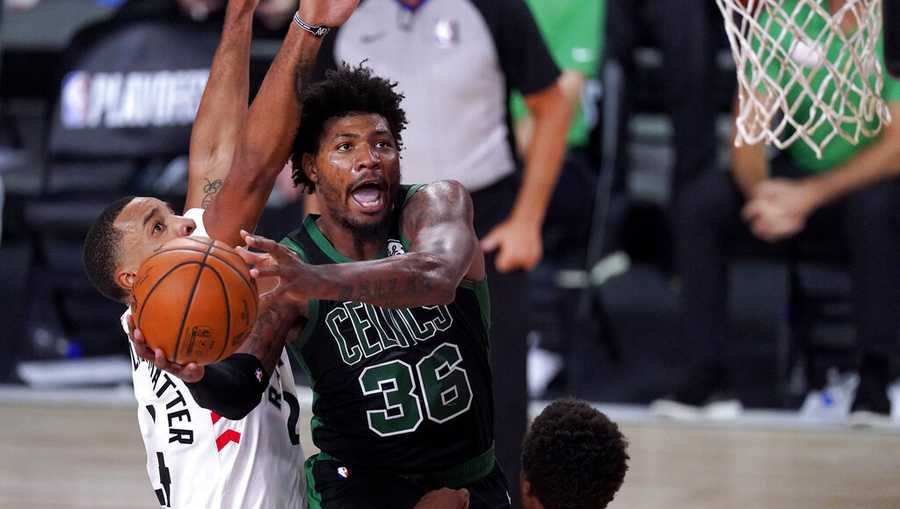 Boston Celtics&apos; Marcus Smart (36) goes up for a shot against Toronto Raptors&apos; Norman Powell, left, and Kyle Lowry during the second half of an NBA conference semifinal playoff basketball game Friday, Sept. 11, 2020, in Lake Buena Vista, Fla. (AP Photo/Mark J. Terrill)