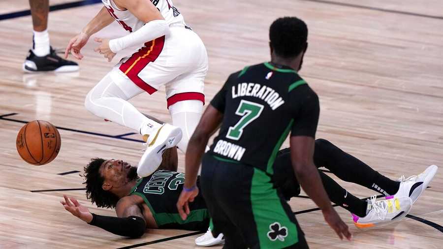 Miami Heat guard Tyler Herro (14) loses control of the ball as he works against Boston Celtics guard Marcus Smart, bottom, and Jaylen Brown (7) during the second half of an NBA conference final playoff basketball game, Thursday, Sept. 17, 2020, in Lake Buena Vista, Fla. (AP Photo/Mark J. Terrill)