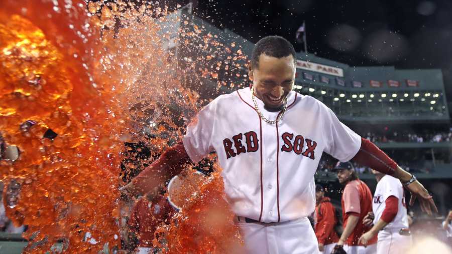 Boston Red Sox's Mookie Betts is doused after his walk-off two-run double during the ninth inning of a baseball game against the St. Louis Cardinals in Boston, Wednesday, Aug. 16, 2017. The Red Sox won 5-4.