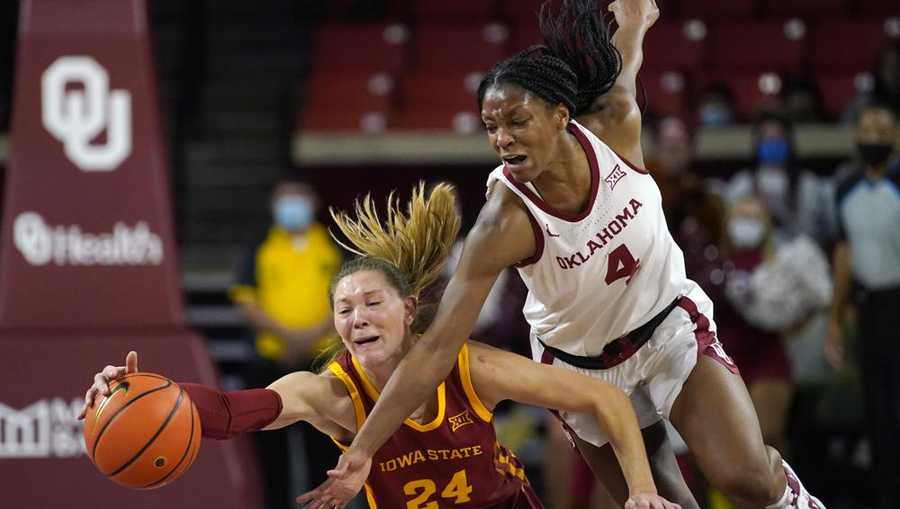 Iowa State guard Ashley Joens (24) and Oklahoma guard Kennady Tucker (4) reach for the ball in the second half of an NCAA college basketball game Wednesday, Jan. 5, 2022, in Norman, Okla. (AP Photo/Sue Ogrocki)