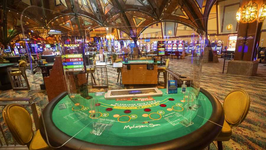 Plexiglass separates guests from each other and the dealer at the Black Jack tables at the Mohegan Sun casino, Thursday, May 21, 2020, in Uncasville, Conn. Connecticut&apos;s two federally recognized tribes, Mashantucket Pequot and Mohegan tribes, said they&apos;re planning to reopen parts of their southeastern Connecticut casinos on June 1, despite Gov. Ned Lamont saying it&apos;s too early and dangerous.   (AP Photo/Mary Altaffer)