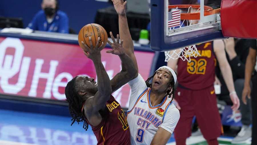 Cleveland Cavaliers forward Taurean Prince (12) shoots in front of Oklahoma City Thunder center Moses Brown (9) during the second half of an NBA basketball game Thursday, April 8, 2021, in Oklahoma City. (AP Photo/Sue Ogrocki)