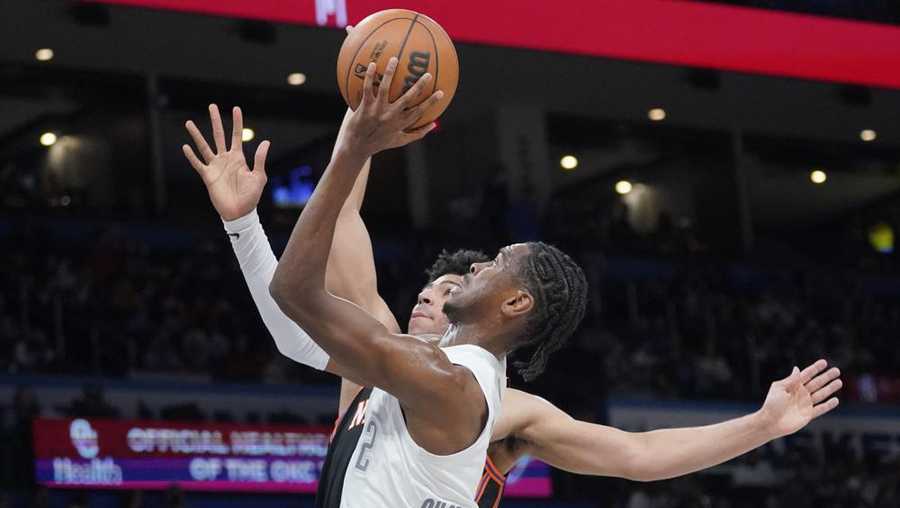 Oklahoma City Thunder guard Shai Gilgeous-Alexander (2) shoots in front of New York Knicks guard Quentin Grimes during the second half of an NBA basketball game Friday, Dec. 31, 2021, in Oklahoma City. (AP Photo/Sue Ogrocki)