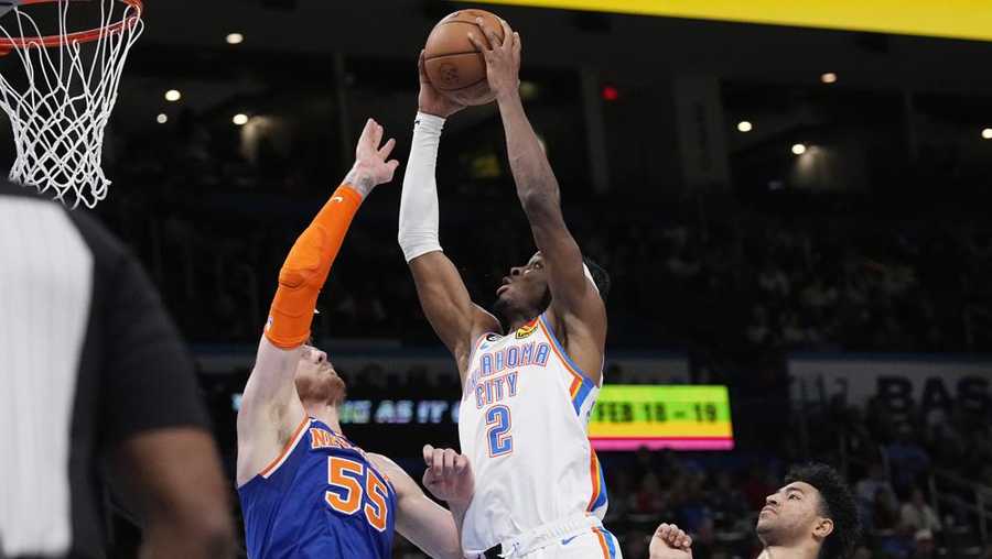 Oklahoma City Thunder guard Shai Gilgeous-Alexander (2) goes up to shoot between New York Knicks center Isaiah Hartenstein (55) and guard Quentin Grimes (6) in the second half of an NBA basketball game Monday, Nov. 21, 2022, in Oklahoma City. (AP Photo/Sue Ogrocki)
