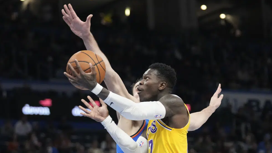 Los Angeles Lakers guard Dennis Schroder, front, goes to the basket past Oklahoma City Thunder forward Dario Saric, rear in the second half of an NBA basketball game Wednesday, March 1, 2023, in Oklahoma City. (AP Photo/Sue Ogrocki)
