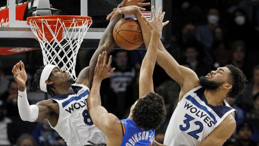 Oklahoma City Thunder center Jeremiah Robinson-Earl (50) tries to go to the basket as Minnesota Timberwolves forward Jarred Vanderbilt (8) and center Karl-Anthony Towns (32) defend him in the first quarter of an NBA basketball game Wednesday, Jan. 5, 2022, in Minneapolis. (AP Photo/Bruce Kluckhohn)