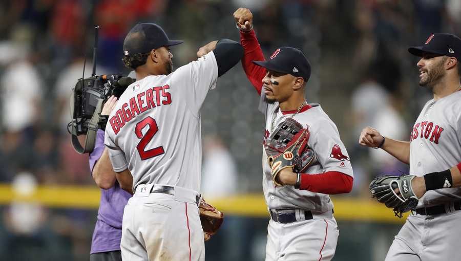 Boston Red Sox shortstop Xander Bogaerts (2) celebrates with right fielder Mookie Betts and left fielder J.D. Martinez, right, after the team's 7-4 win in a baseball game against the Colorado Rockies on Wednesday, Aug. 28, 2019, in Denver. (AP Photo/David Zalubowski)