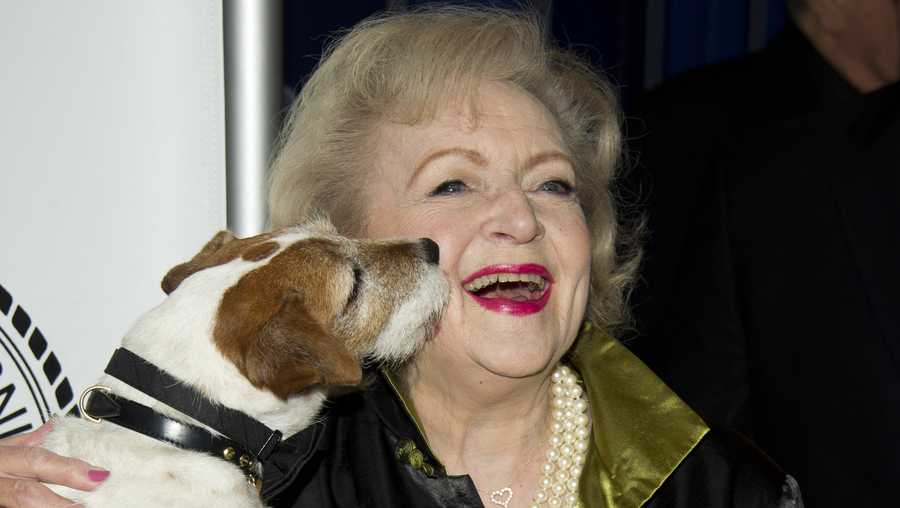 Betty White poses with Uggie the dog from the film 'The Artist' as she arrives for her Friars Club Roast in New York, Wednesday, May 16, 2012. (AP Photo/Charles Sykes)