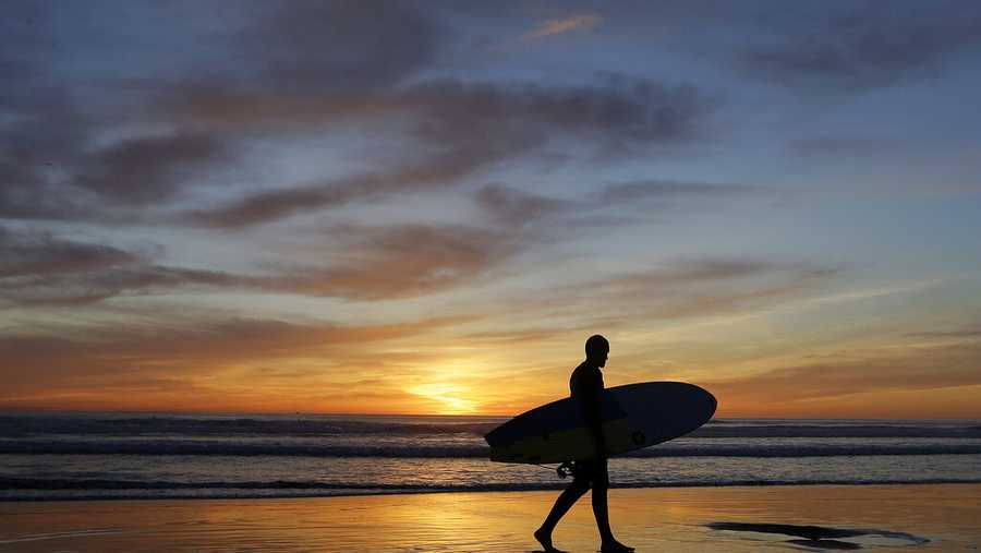 Mike O&#39;Neill leaves the water after surfing at Ocean Beach in San Francisco, Wednesday, April 6, 2016. A handful of spring heat records are expected to be broken on Wednesday but then temperatures will fall and the weekend is forecast to be wet. (AP Photo/Jeff Chiu)