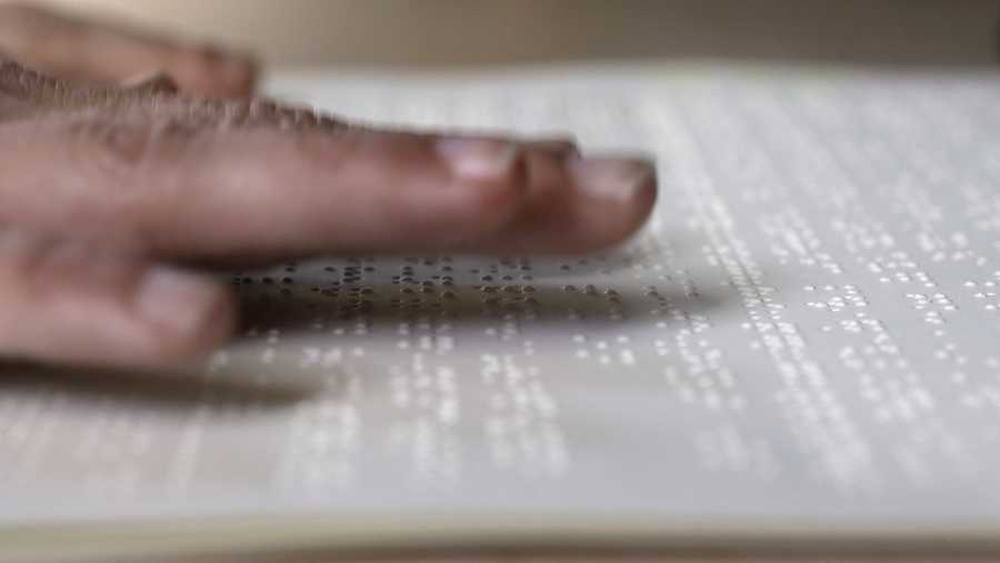 In this Tuesday, Oct. 17, 2017 photo proofreader Georgie Sydnor runs her fingers over braille at the National Braille Press in Boston. The Boston-based organization has been a leading force for braille literacy in the U.S., since its founding as a weekly newspaper for the blind in 1927. But it now is confronting a record low literacy in the writing system for the blind as it marks its 90th birthday this year. (AP Photo/Steven Senne)