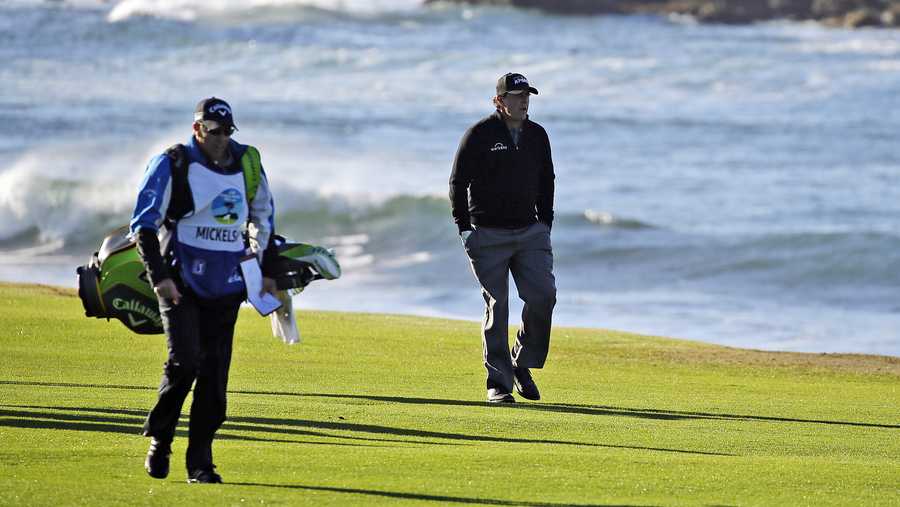 FILE - In this Feb. 11, 2019, file photo Phil Mickelson walks up the 18th fairway of the Pebble Beach Golf Links with his brother and caddie Tim Mickelson during the final round of the AT&T Pebble Beach Pro-Am golf tournament in Pebble Beach, Calif. At Pebble Beach, a course teeming with history for Mickelson, the 48-year-old, five-time major champion will come face to face with what might be his last, best chance to win the U.S. Open and become the sixth player to complete the career Grand Slam.  (AP Photo/Eric Risberg, File)