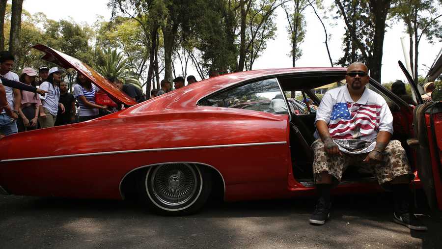 Carlos Rivas poses for a photograph inside his 1967 Chevrolet Impala Super Sport on exhibit at a lowriders and lowbikers show in Mexico City, Mexico, Sunday, Aug. 11, 2019. The 36-year-old said he has been tuning his car for two years. (AP Photo/Ginnette Riquelme)