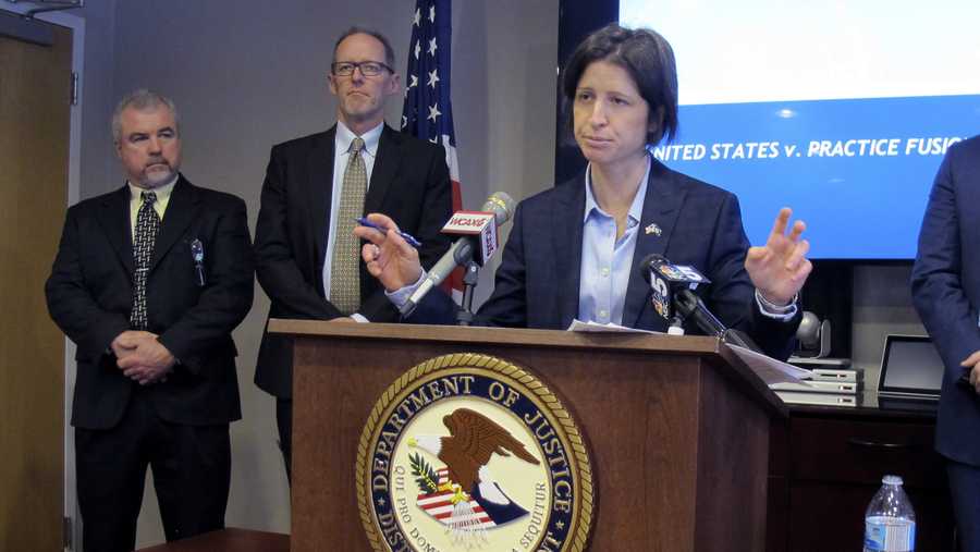 U.S. Attorney Christina Nolan, center, gestures during a news conference in Burlington, Vt., Monday Jan. 27, 2020. Nolan announced that a health information technology company will pay $145 million to resolve criminal and civil charges that it helped set up an electronic health records system that encouraged physicians to prescribe opioids to people who might not need them. (AP Photo/Wilson Ring)