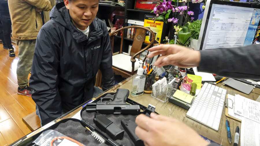 FILE -- Brian Xia, 44, picks up his gun at a gun store in Arcadia, Calif. Sunday, March 15, 2020. Xia who is a first-time gun buyer, says he buys the gun for protecting himself and his family. (AP Photo/Ringo H.W. Chiu)