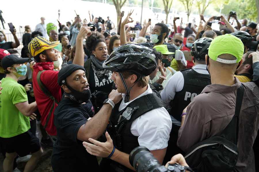 Demonstrators in Washington D.C. argue with uniformed U.S Secret Service police officers during a protest about the death of George Floyd. (AP Photo/Evan Vucci)